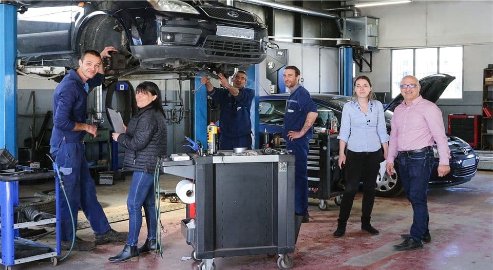 un groupe de personne dans un garage automobile